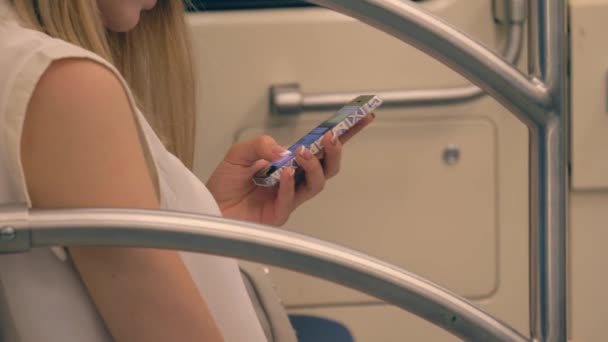 Närbild av Hand unga kaukasiska kvinna använder Smartphone Apps turer i tunnelbanan — Stockvideo