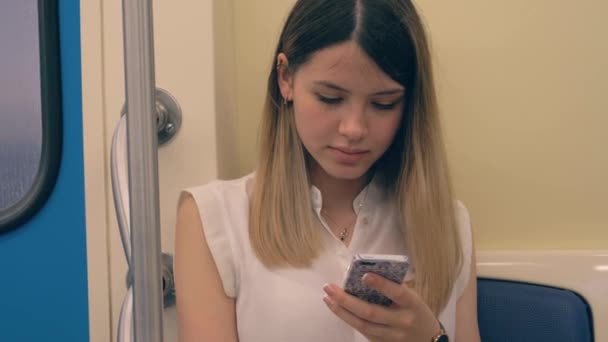 Retrato de jovem linda mulher branca usando um aplicativo de smartphone em um metrô — Vídeo de Stock