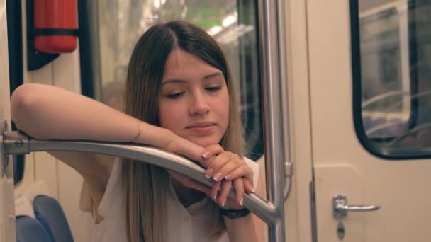 Smutne, że młoda kobieta kaukaski oparł się jej głowa i ręka na poręczy w metrze — Wideo stockowe