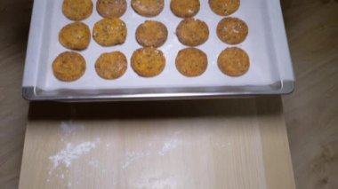 Cook elinde masada bitmiş kurabiye pişirme tepsisi fırından koymak