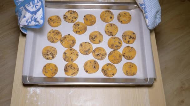 Mãos de cozinheiro colocar na mesa uma bandeja de cozimento de biscoitos acabados do forno — Vídeo de Stock