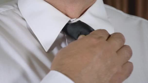 Hombres maduros manos corregidas nudo de corbata en el cuello de una camisa blanca — Vídeos de Stock