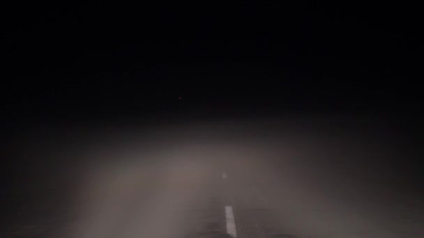 В вождении автомобиля в дороге ночью в густом тумане и плохой видимости — стоковое видео