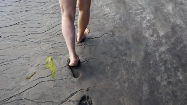 Voeten van een oudere blanke Man Walking On Shore verlaten van merken op zwart zand — Stockvideo