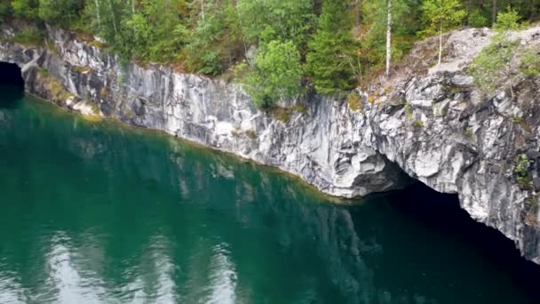 Laguna blu a riva con scogliere rocciose con grotte — Video Stock