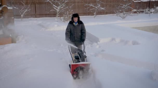 冬天, 一个人在降雪后清除道路, 除雪机 — 图库视频影像