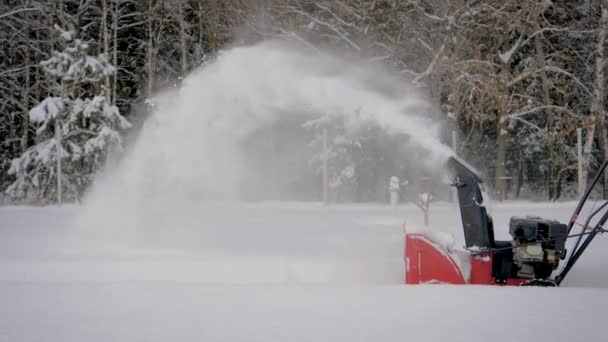 El trabajador que controla el flujo de nieve limpia la nieve en invierno después de la nevada — Vídeos de Stock