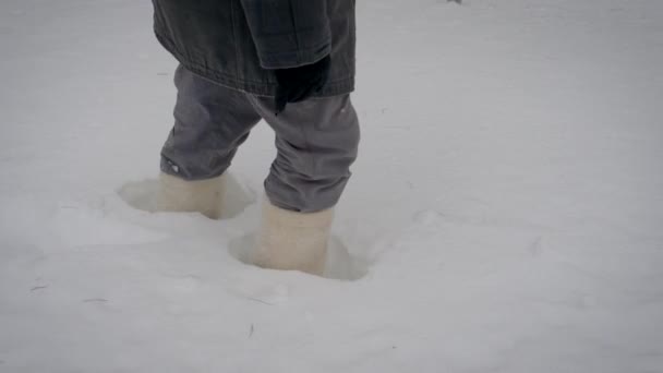 V pohybu nohy v teplé boty chůze v hlubokém sněhu závěje v zimě — Stock video