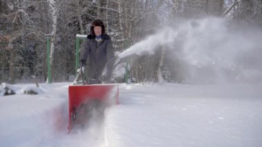 Adam kar kar temizleme makinesi arka plan orman ile kışın temizler.