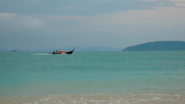 Barco de motor de pesca flutuando no mar com água azul-turquesa no fundo das ilhas — Vídeo de Stock