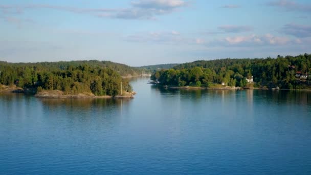 Schöne Meeresbucht mit Inseln, auf denen Häuser im Kiefernwald im Licht des Sonnenuntergangs stehen — Stockvideo