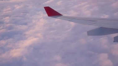 Günbatımı ışığında gökyüzünde bulutlar üzerinde uçuş sırasında uçağın kanat döner