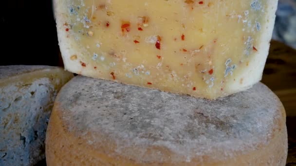 Cercle de fromage et couper un morceau de fromage et des morceaux de poivre rouge — Video