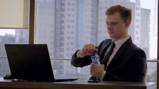 Obchodník sedí na pracovišti jako okno v kanceláři a pitná voda — Stock video