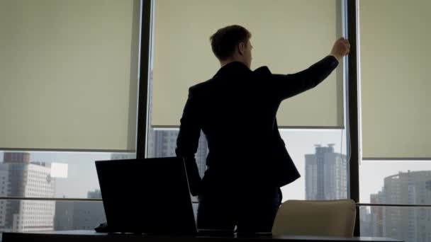 Businessman In Office Standing At Window And Opens The Blinds To Make Brighter — Stock Video