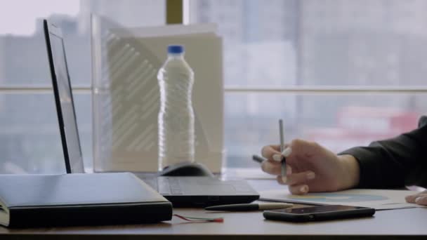 Händer kvinna Creative Director sitter vid skrivbordet gör anteckningar med penna på diagram — Stockvideo