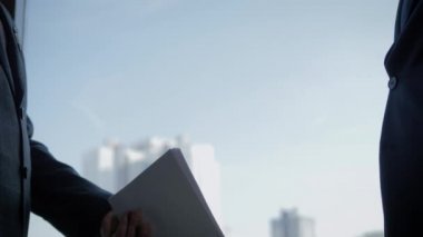 İşadamları sözleşme belgelerini geçti ve ofiste ki pencerede el sıkıştı