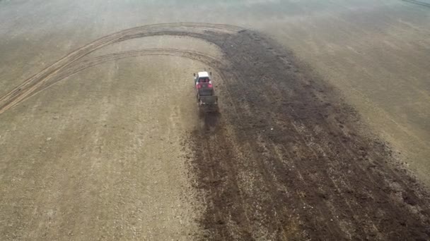Trattore agricolo guidare attraverso il campo agricolo e fertilizzarlo con letame — Video Stock