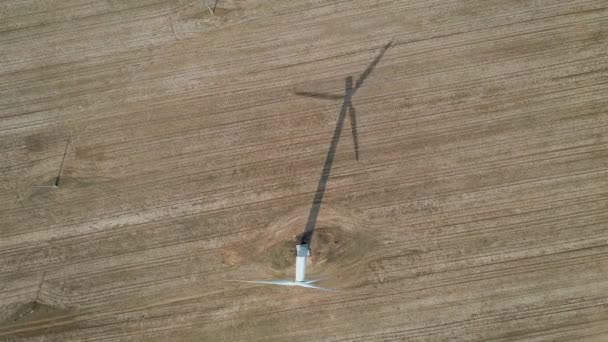 Вид на робочу вітротурбіну та її тінь у полі — стокове відео