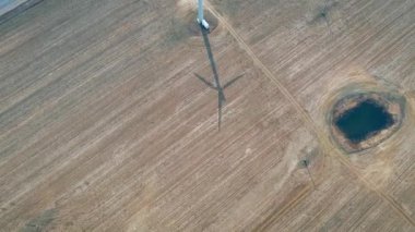 Çalışan bir rüzgar türbini ve alan ve karayolu onun gölgesi üst görünümü