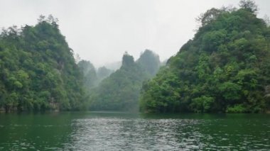 Zhangjiajie Dağları'nın Nehir Manzarası Sis ve Yağmurda Tropikal Ormanı Kapsıyor