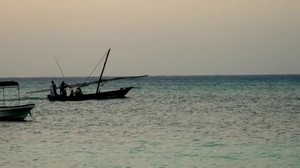 Silhouette fiskebåt med fiskare seglar på havet på kvällen — Stockvideo