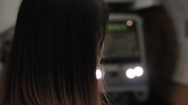 Femme se tient à la station de métro sur le fond d'un train à venir — Video