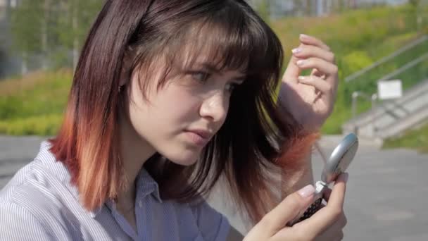 Aantrekkelijke blanke vrouw preening en recht haar haar op zoek in spiegel — Stockvideo