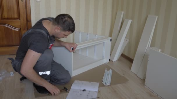 Arbeiter bei der Montage von Möbeln schlägt mit Hammer auf die Nägel Befestigungsmaterial — Stockvideo