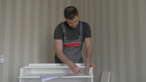 Arbets möbler monteringsskruvar med en skruvmejsel delar bröstet — Stockvideo
