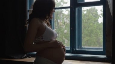 Güzel Hamile Kadın Pencere yakınında Duran Göbek El Okşayarak