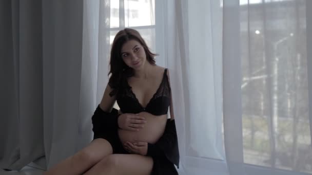 Pregnant Woman Sitting On The Windowsill At The Window And Posing — Stock Video