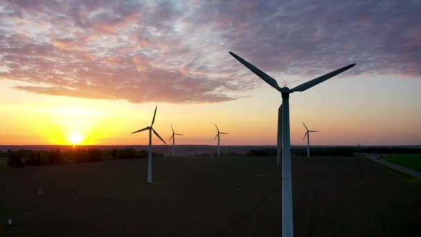 Vista aérea da produção de energia de turbinas de moinho de vento ao pôr do sol — Vídeo de Stock