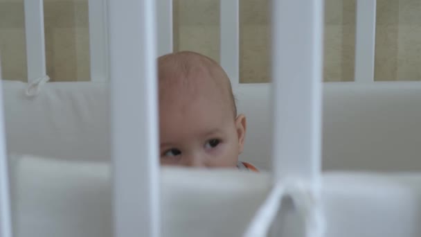 Baby speelt en kauwt speelgoed in de wieg — Stockvideo