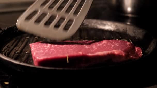 Кухар нарізає шматки м'ясних стейків на сковороді — стокове відео