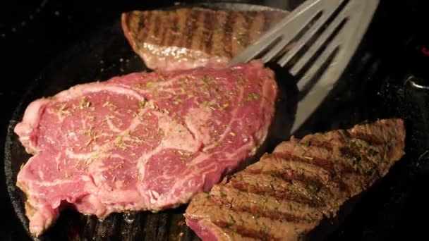 Närbild av en kock vända en biff på grillen med en spatel — Stockvideo