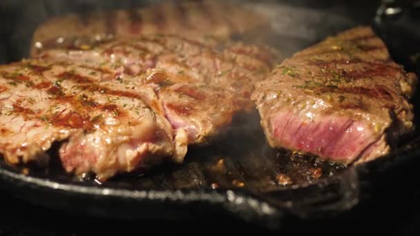 Close-up de carne de bifes de cozinha em uma panela de grelha na cozinha — Vídeo de Stock