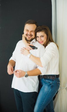 Cilt Bakımı. Güzel kadın, elinde bir şişe yüz kremi tutan, Genç bir gülüyor neşeli adam sarılmak. Koruma ve Cilt Bakımı