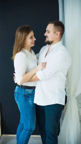 Stilvolles Paar, Mann und Frau in weißen Hemden und Jeans, die sich umarmen. Foto in leuchtenden Farben — Stockfoto