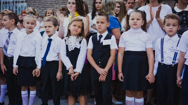 Zaporozhye, Ukraine - September 1, 2018: first-graders stand on a ruler in the open air with teachers and high school students on the ceremonial school line on the day of knowledge. — Stock Photo, Image
