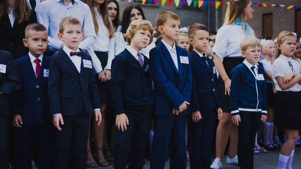 Zaporozhye, Ukraine - September 1, 2018: first-graders stand on a ruler in the open air with teachers and high school students on the ceremonial school line on the day of knowledge. — Stock Photo, Image