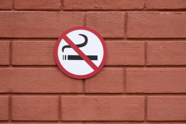 Kırmızı tuğla duvarda sigara içilmez. Boşluğu kopyala.