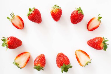 Bütünün oval çerçevesi ve beyaz arka planda yarı yarıya çilek. İzole edilmiş. Boşluğu kopyala.