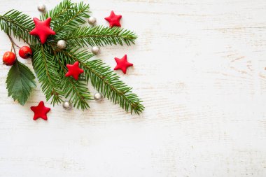 Yeşil ladin, kırmızı yıldızlar, böğürtlen ve beyaz inci boncuklu Noel ve yeni yıl tasarımı. Beyaz ahşap arka plan. Uzayın bir kopyası. 