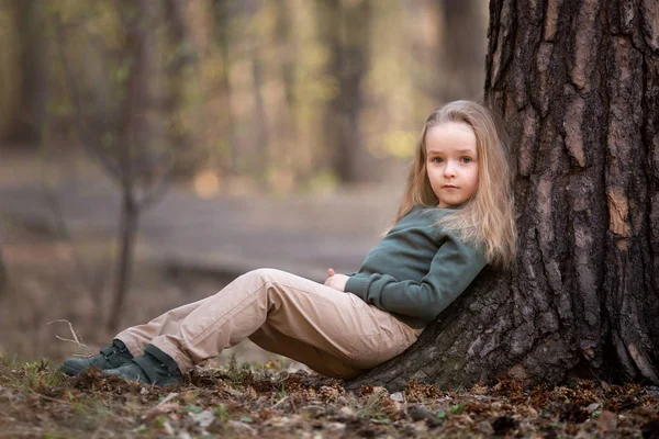 Girl is sitting under the tree in the park — Stock Photo, Image