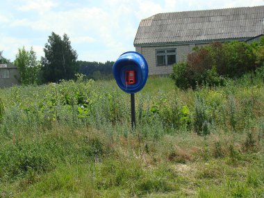 Bir ankesörlü telefon kırsal bir manzaranın ortasında duruyor.