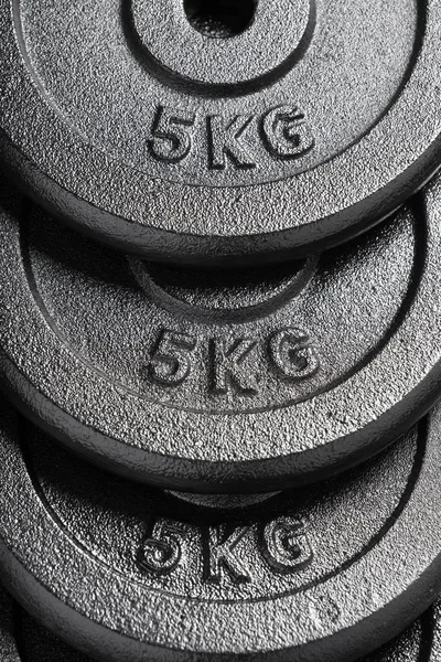 Pila de placas de peso de barra / mancuerna de 5 kg dentro de un gimnasio de levantamiento de pesas — Foto de Stock