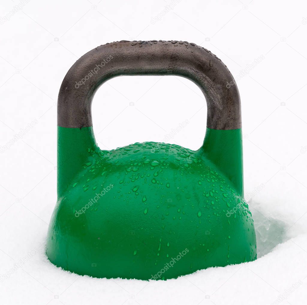 Frozen green gym kettlebell in the snow