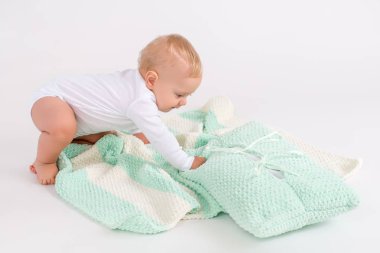 Beyaz arka plan üzerinde peluş çizgili çift renkli battaniye ile Çocuk