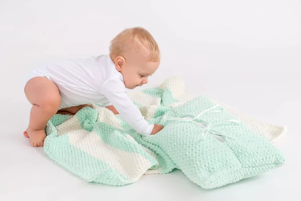 Kid with the plush striped double colored blanket on the white background — Stock Photo, Image